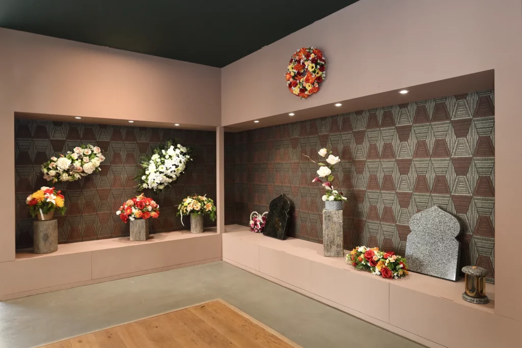 Showroom d'articles funéraires présentant fleurs, stèles et plaques du souvenir.